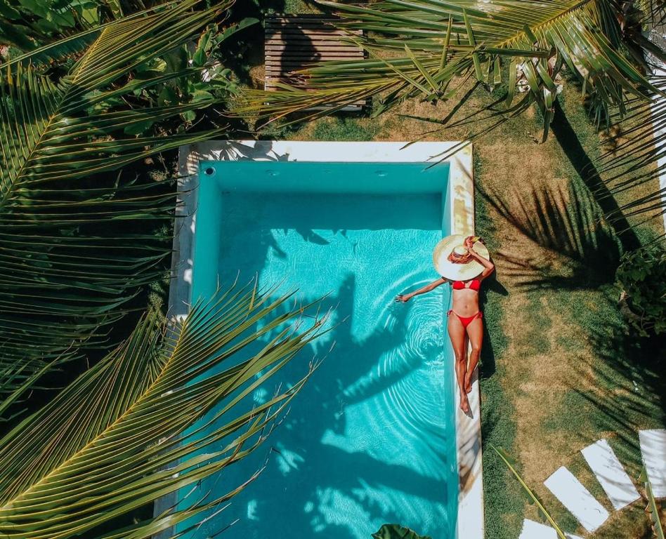 a doll in a bikini standing next to a swimming pool at Vilamaré Gostoso in São Miguel do Gostoso
