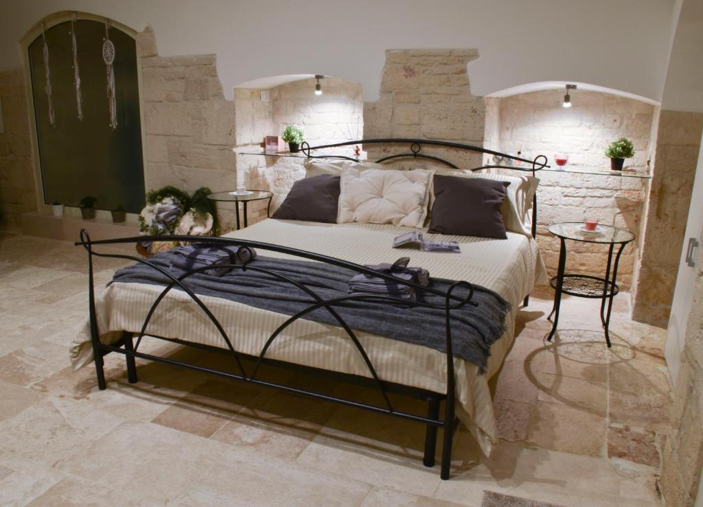 a bedroom with a wrought iron bed and two tables at B&B borgo del capitolo in Santeramo in Colle