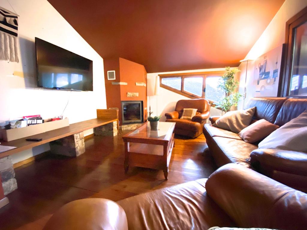 TV a/nebo společenská místnost v ubytování Isards, Atico rustico con chimenea en el tarter, zona Grandvalira