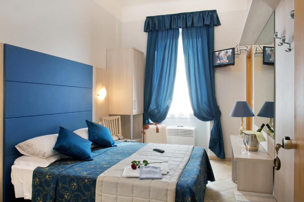 a blue bedroom with a bed and a window at Albergo Marechiaro in Rome