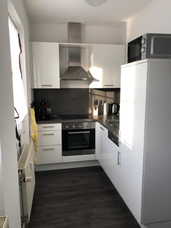 a kitchen with white cabinets and a stove top oven at Beatles in Clausen