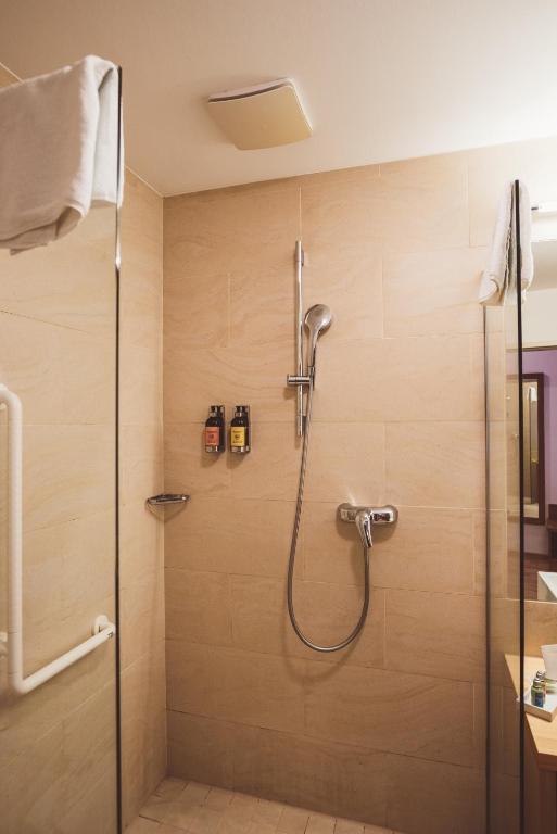 a shower with a glass door in a bathroom at Heritage Hotel Hallstatt in Hallstatt
