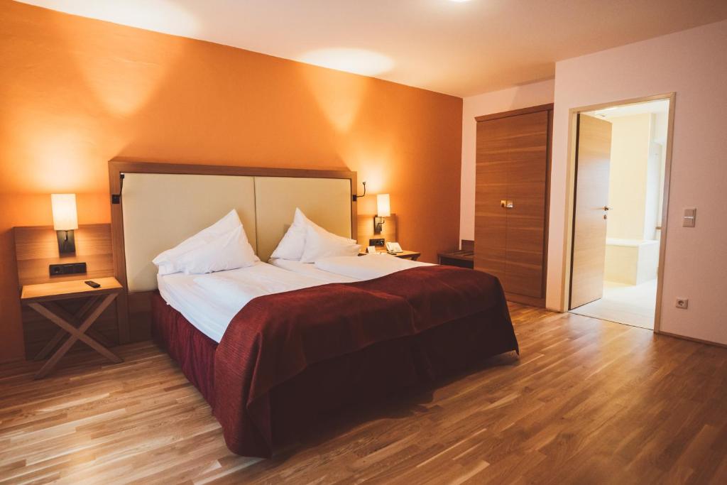 a bedroom with a large bed with orange walls at Heritage Hotel Hallstatt in Hallstatt