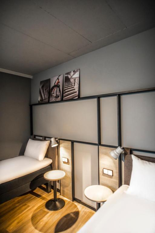 una camera con due letti e due sgabelli di ibis Wels a Wels