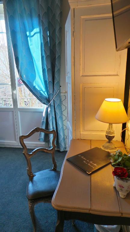 a chair and a desk with a laptop and a lamp at Hotel Relais Du Postillon in Antibes
