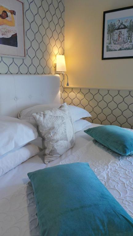 a large white bed with two pillows on it at Hotel Relais Du Postillon in Antibes