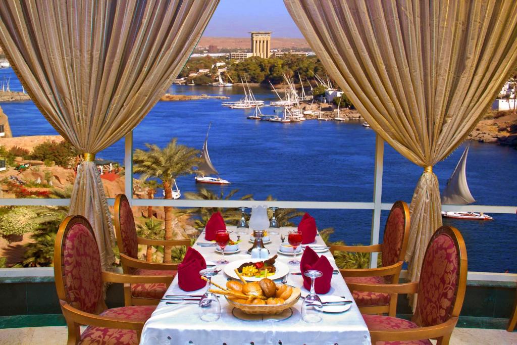 a table with a bowl of food and a view of the water at Tolip Aswan Hotel in Aswan