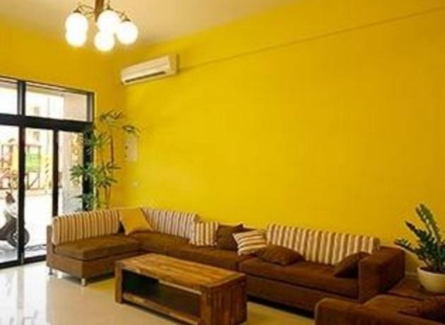 馬公市的住宿－岑之堡民宿，黄色的客厅配有沙发和桌子