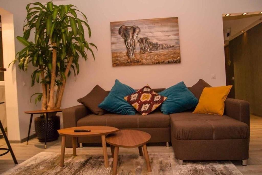 a living room with a brown couch with colorful pillows at Colonial Touch Apartament in Braşov