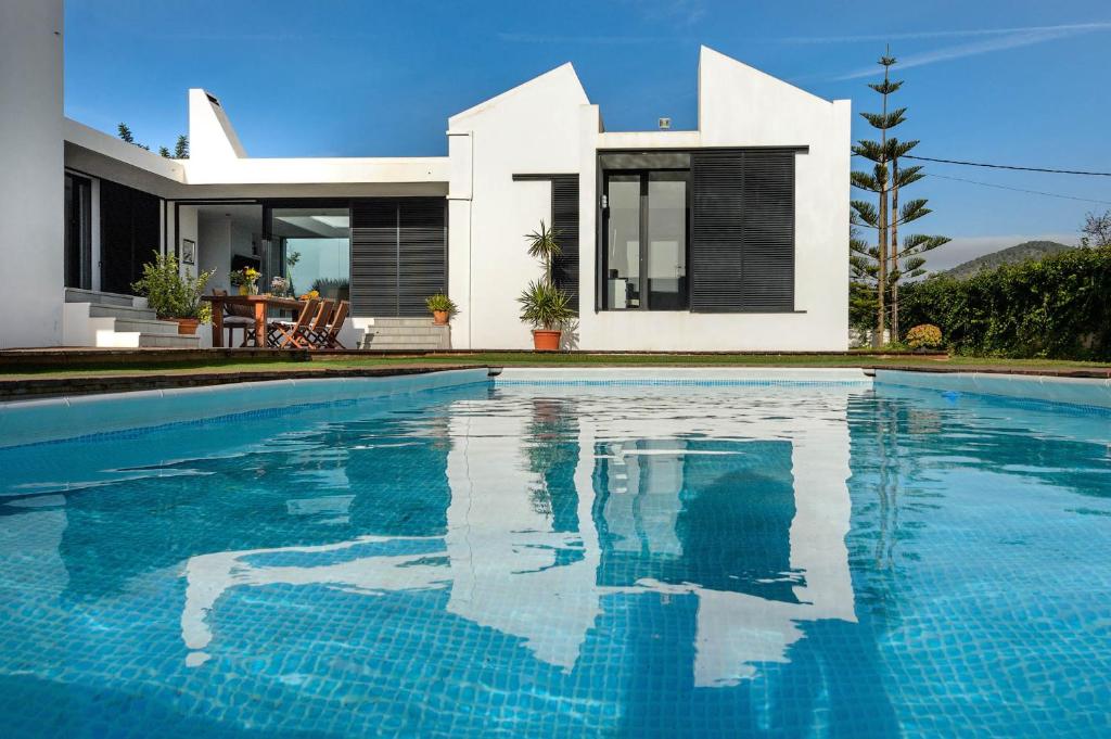 uma casa com piscina em frente a uma casa em Villa Anur em San Jose de sa Talaia