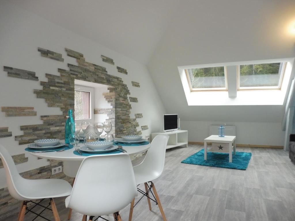 une salle à manger avec une table et des chaises blanches dans l'établissement Le petit Kichon, à Gérardmer