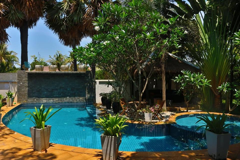 暹粒的住宿－Private Entire 8 BedRooms Garden Pool Villa With Kitchen & BBQ Facilities，棕榈树庭院内的游泳池
