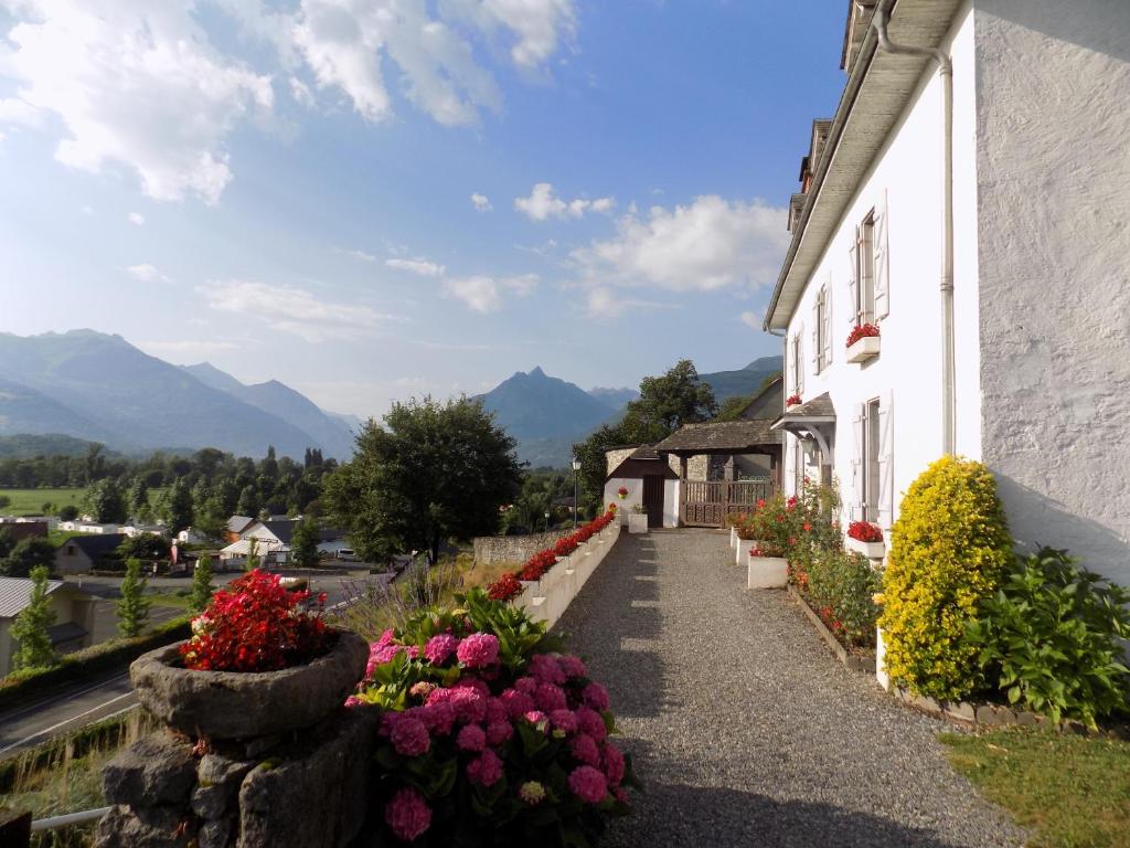 une maison avec des fleurs sur le côté dans l'établissement Maison bigourdane, à Ayzac-Ost
