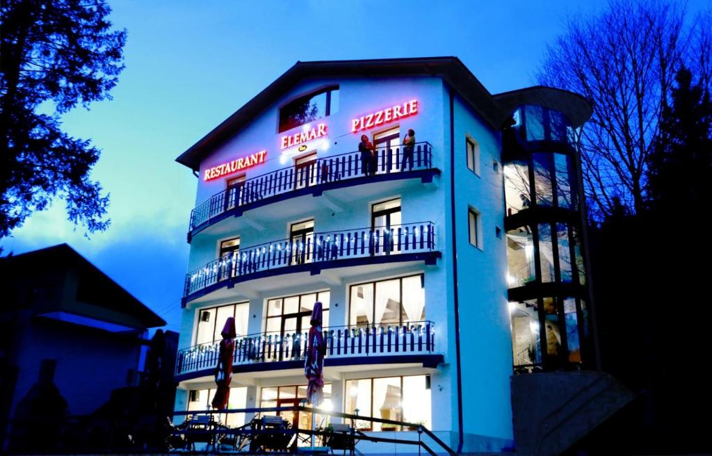 un edificio blu con persone sui balconi di Pensiunea ELEMAR ad Azuga
