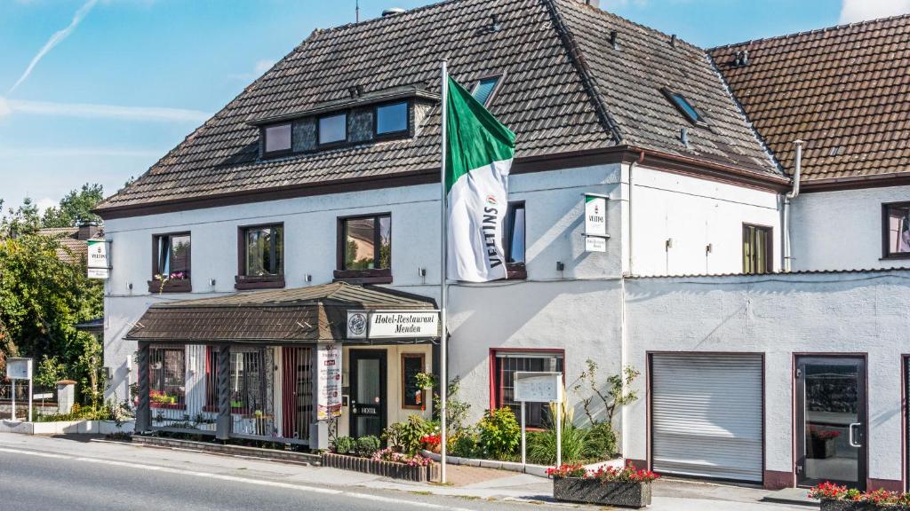 un edificio con una bandera delante de él en Hotel Restaurant Menden, en Menden