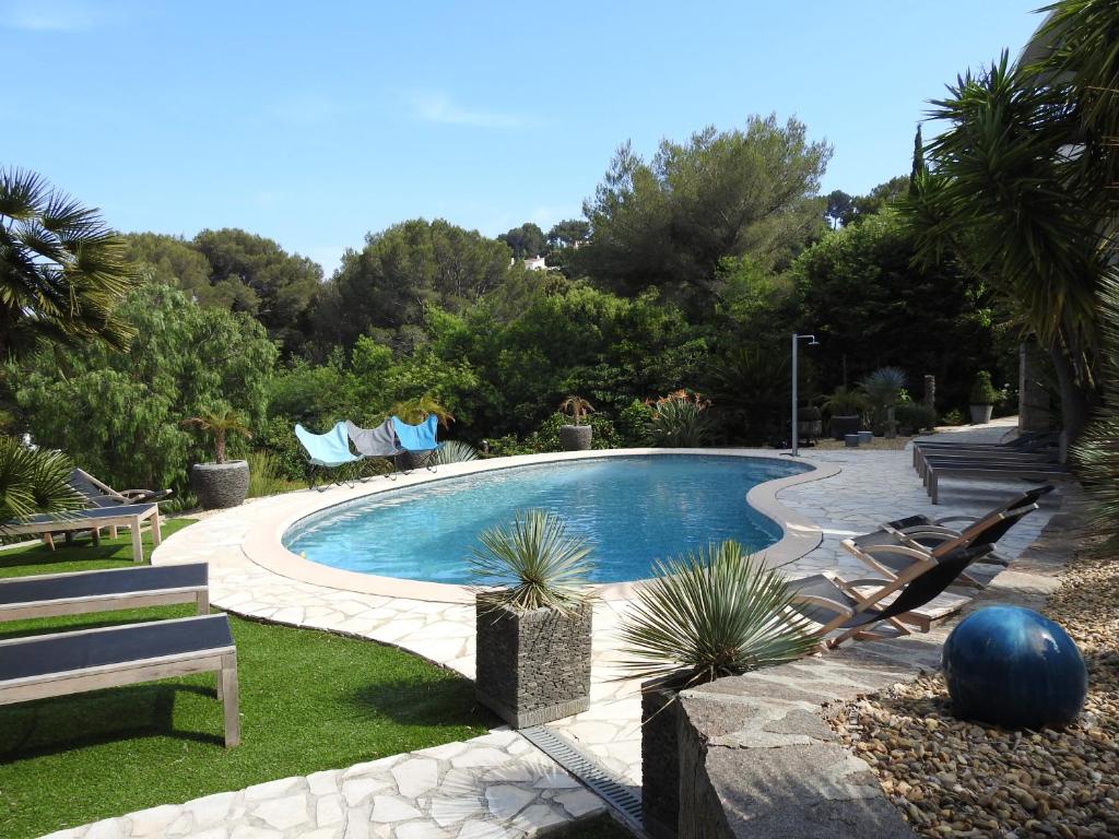 - une piscine avec un banc et des chaises dans la cour dans l'établissement La Cavale En Mer T4 100m², à Cavalaire-sur-Mer