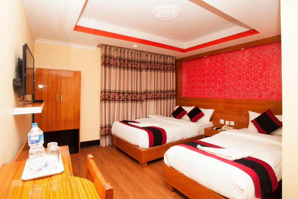 a hotel room with two beds and a table at Kathmandu Regency Hotel in Kathmandu
