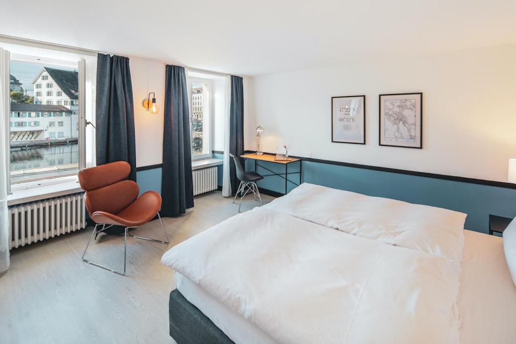 a bedroom with a bed and a desk and a window at Pop Up Hotel Krone Zürich in Zurich