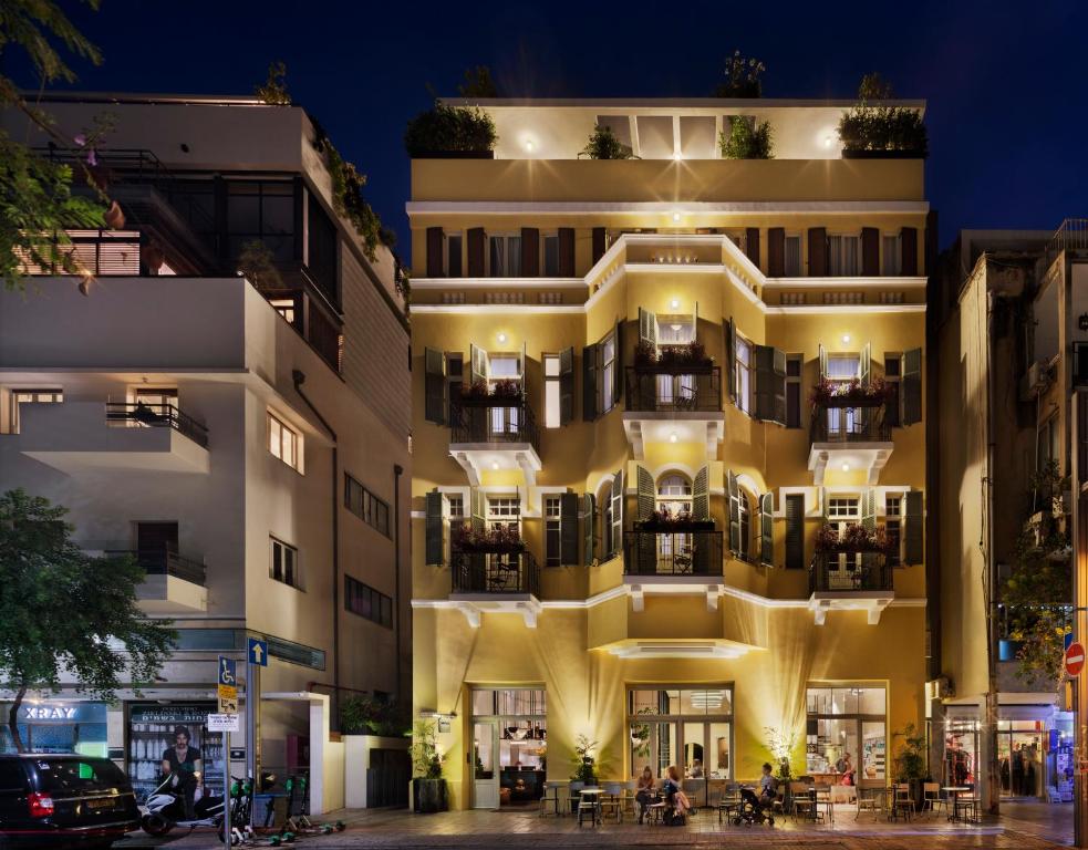 an apartment building with a lit up facade at night at Sam&Blondi in Tel Aviv
