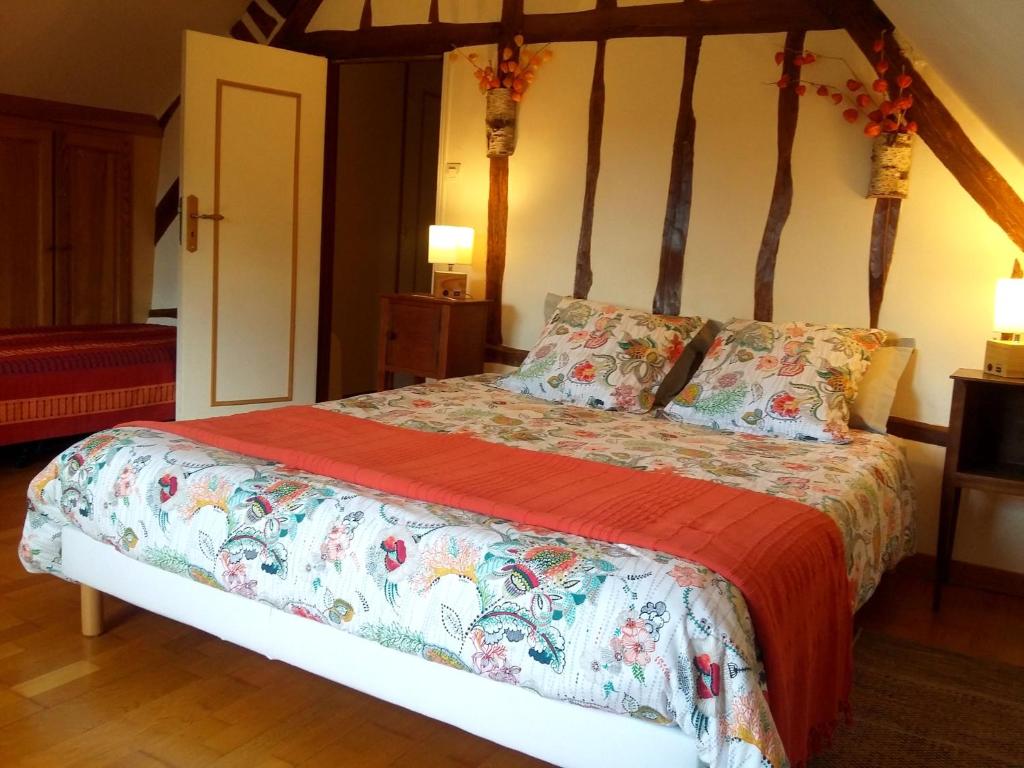 a bedroom with a large bed with a red blanket at La Sauleraie in Frazé