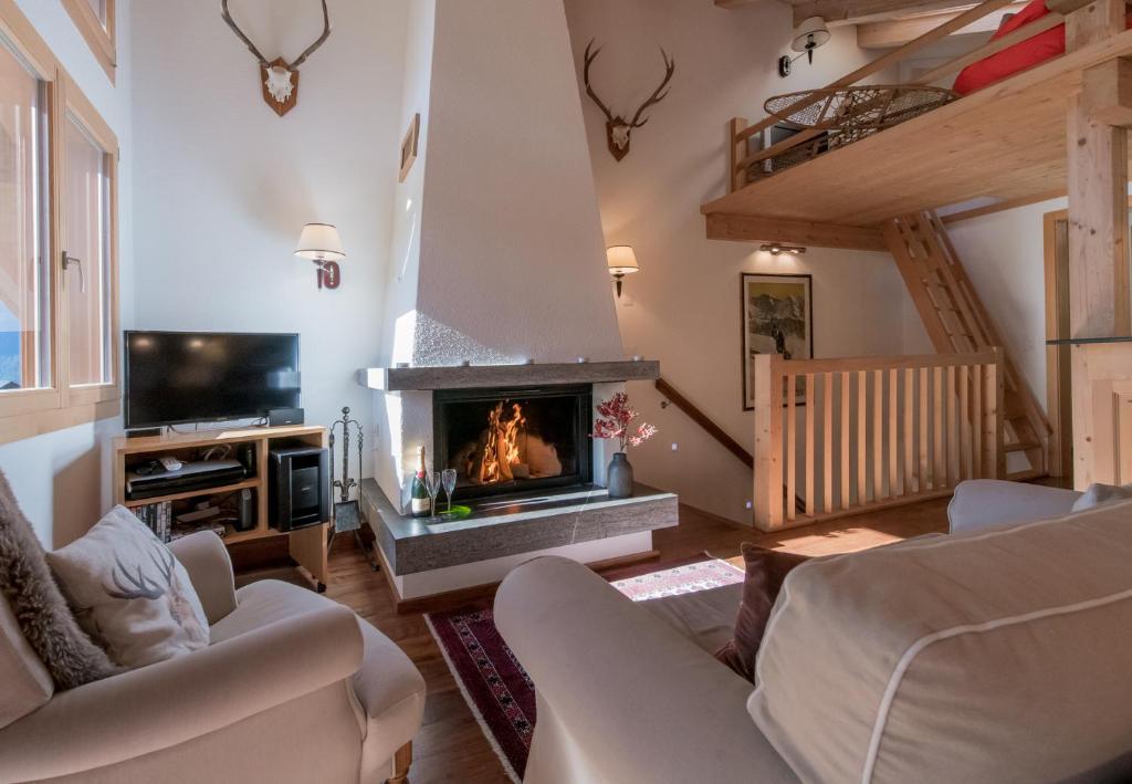 uma sala de estar com lareira e televisão em Chalet Luna em Wengen