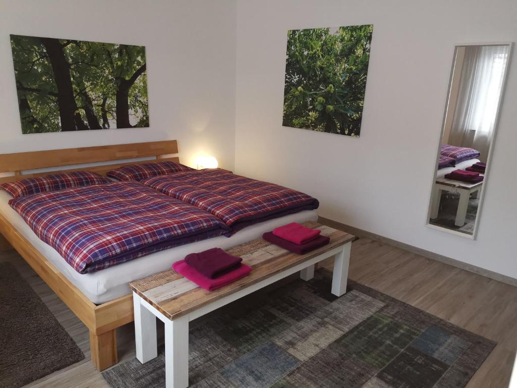 Un dormitorio con una cama con sábanas rojas y una mesa. en Ferienwohnung S-Bahn Nähe, en Schwaikheim