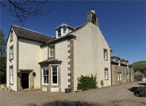 una gran casa de ladrillo blanco con techo en Abbotshaw House Farm B&B en Newcastleton