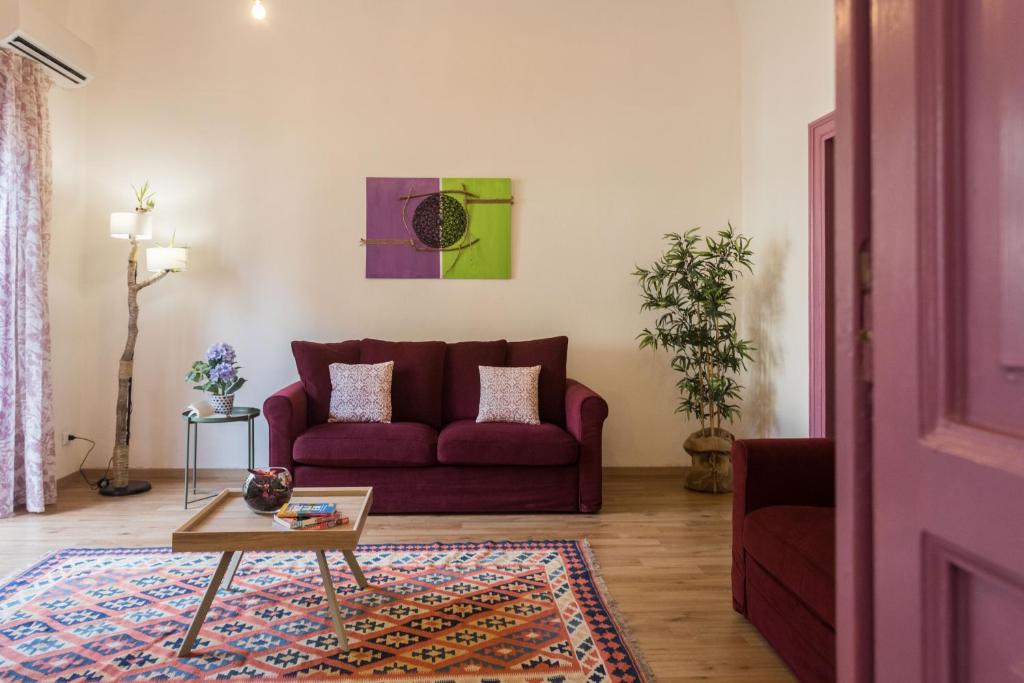 sala de estar con sofá rojo y mesa en Politeama apartment, en Palermo