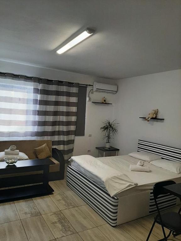 a bedroom with a bed and a chair and a window at Studio Apartment in Chiajna