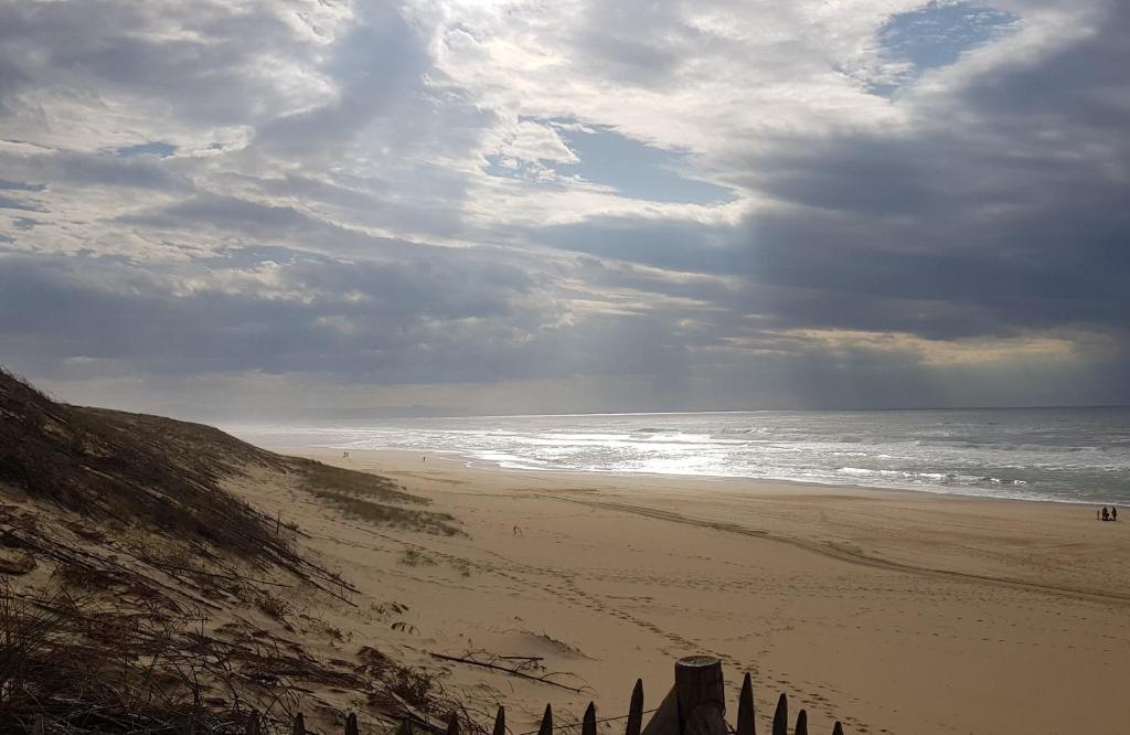 una playa con un cielo nublado y el océano en Résidence VILLAS DU LAC, en Soustons