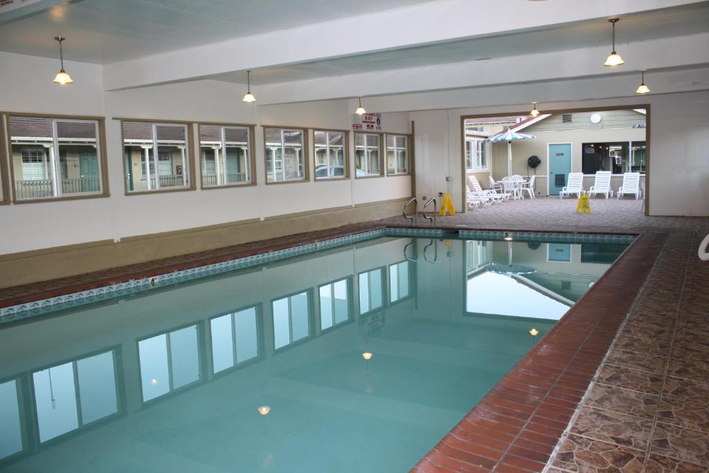a swimming pool with blue water in a building at El Castell Motel in Monterey