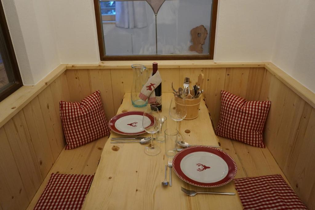 a wooden table in a sauna with plates and glasses at Ferienwohnung Almsuite Fritz in Wald im Pinzgau