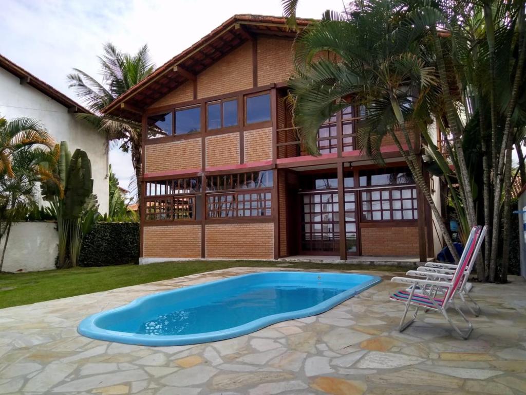 a house with a swimming pool in front of a house at Casa Inteira frente mar in Paraty