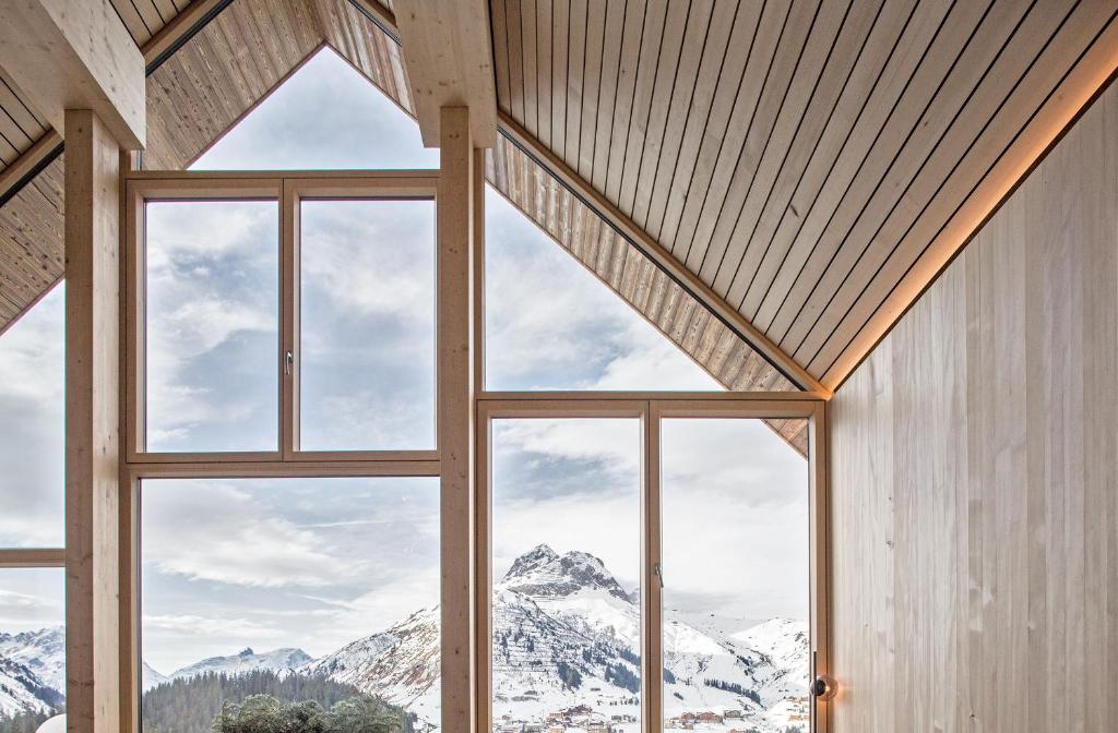 duże okno w pokoju z widokiem na góry w obiekcie HOLZGAUER HAUS w mieście Warth am Arlberg