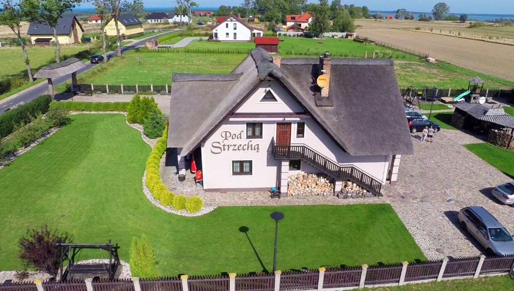 a model of a small house on a green field at Pod Strzechą in Darłowo