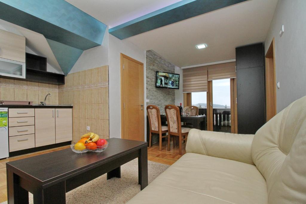 Una sala de estar con un sofá y una mesa con fruta. en Zlatibor Apartments NIKS, en Zlatibor