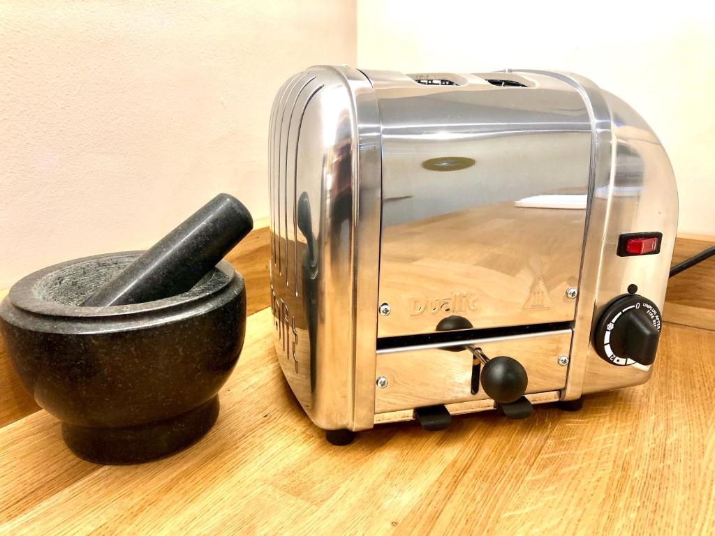 a toaster sitting on a table next to a cup at The Duplex Margate with Deck & Living Space Air Conditioning in Margate