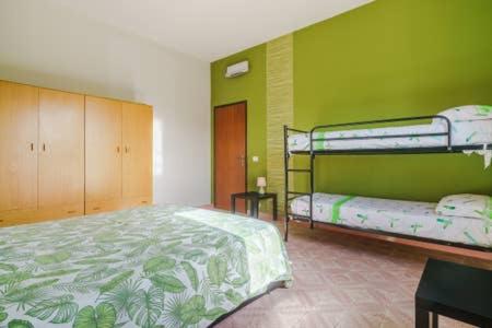 sypialnia z 2 łóżkami piętrowymi i zieloną ścianą w obiekcie Villa Vacanze Giuseppe w mieście Mazara del Vallo