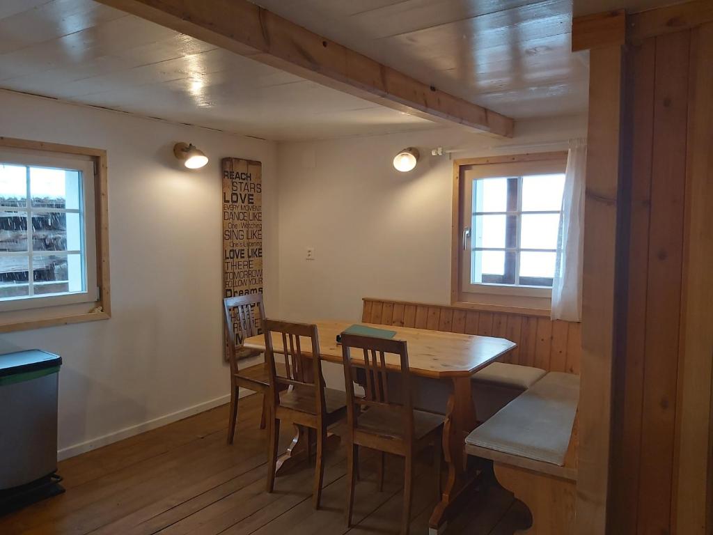 uma sala de jantar com uma mesa de madeira e cadeiras em Tgèsa Felici em Sedrun
