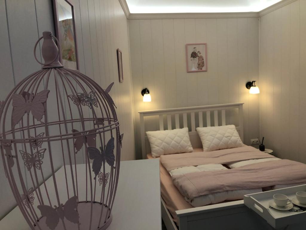 a bedroom with a bed and a bird cage at Dunakavics Boutique Apartman Szentendre in Szentendre