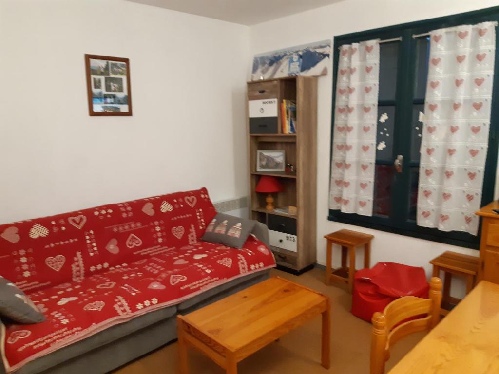 uma sala de estar com um sofá vermelho e uma mesa em Studio Sainte Marie De Campan em Sainte-Marie-de-Campan