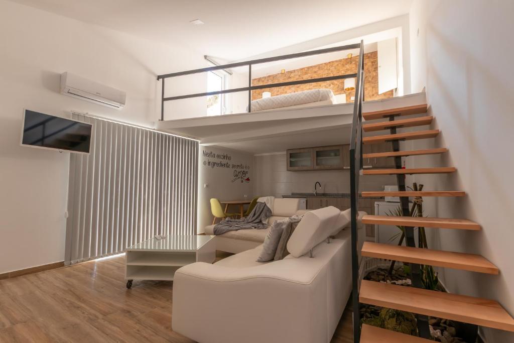uma sala de estar com uma cama alta e um sof em Villa Alzira em Seia