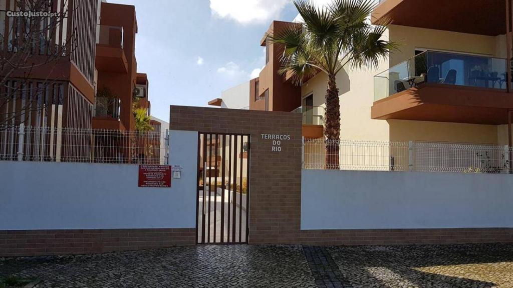 ein Tor zu einem Gebäude mit einer Palme davor in der Unterkunft Terraços do Rio in Portimão