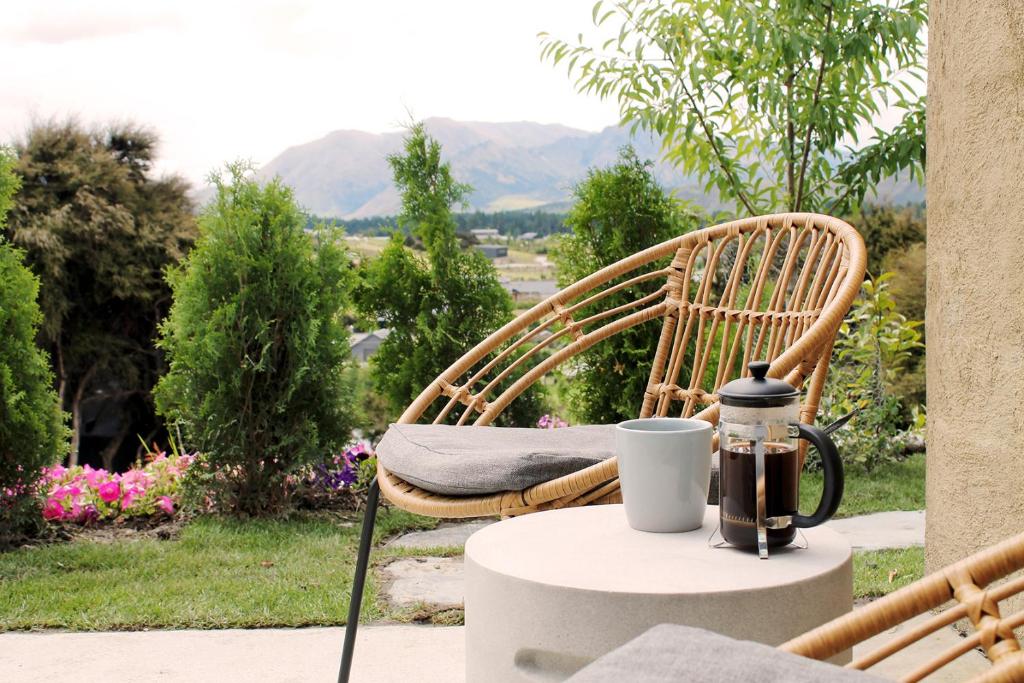 a chair sitting on a table with a coffee cup on it at The Hidden Spring in Wanaka