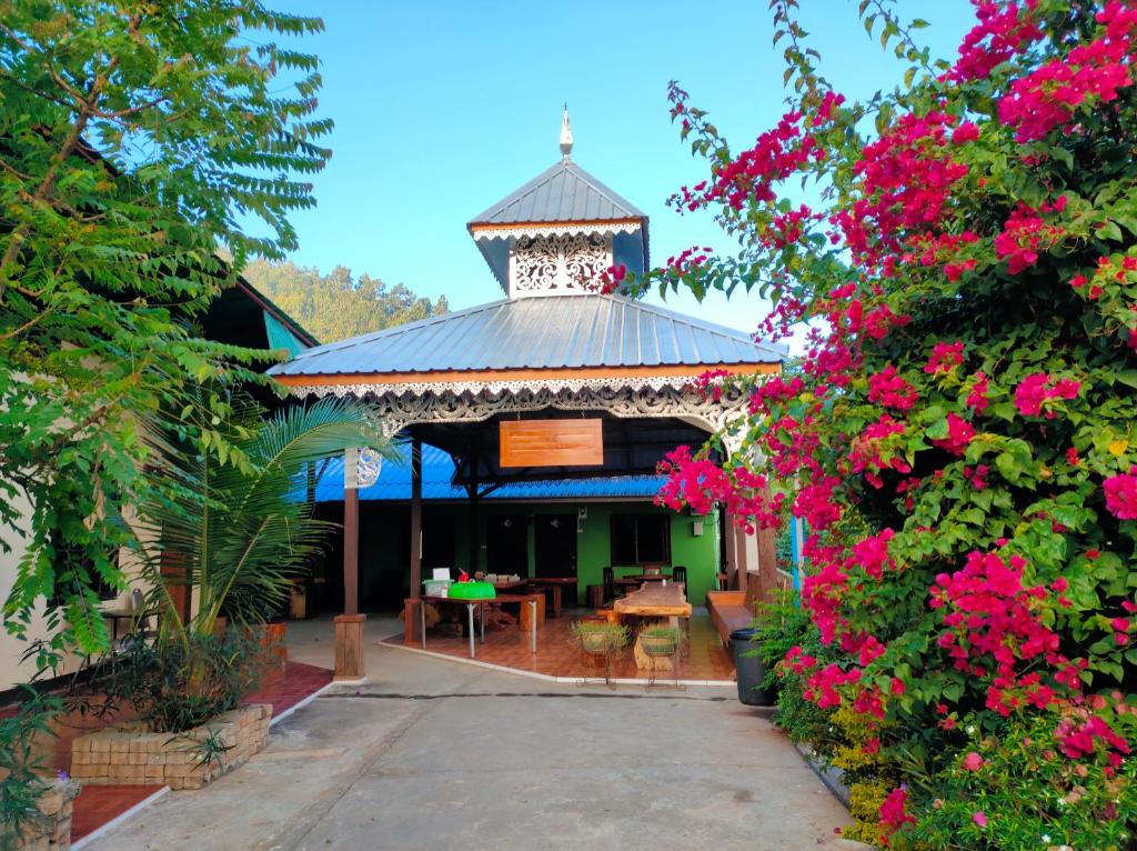 a gazebo with a table and some pink flowers at Boondee House in Mae Hong Son