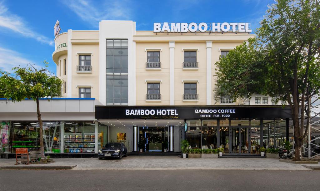 a store front of a building with a car in front at Bamboo Hotel in Da Nang