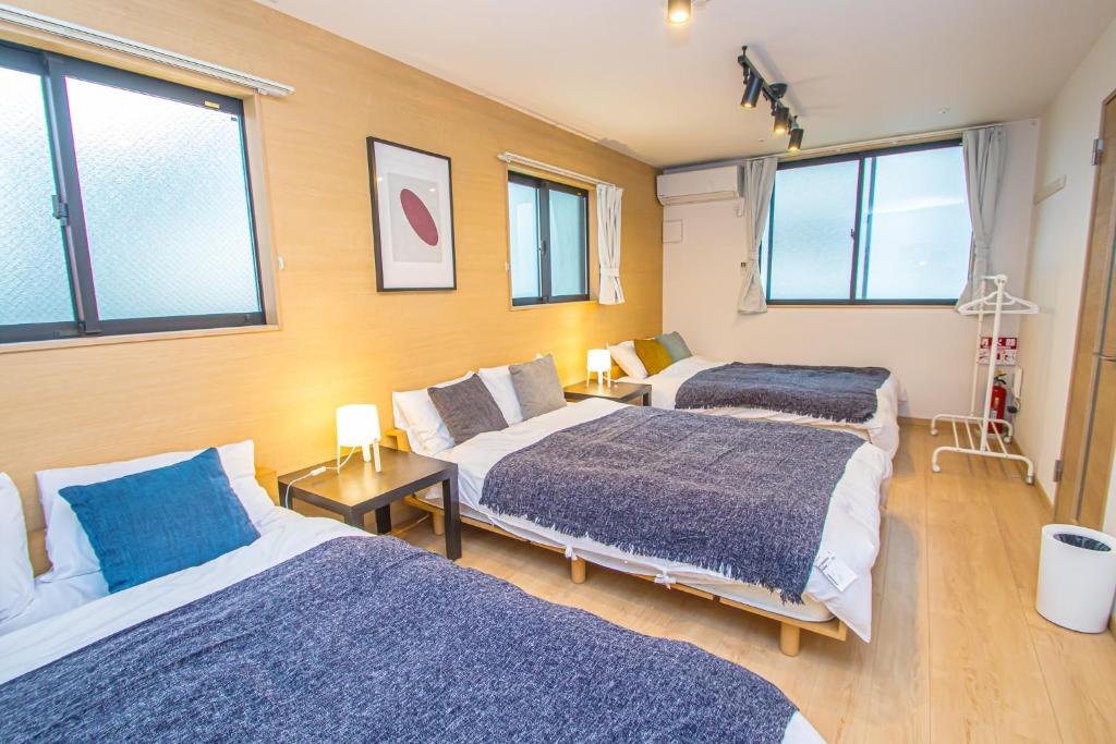 Duas camas num quarto com janelas em LA CHIC Stay Hakata em Fukuoka