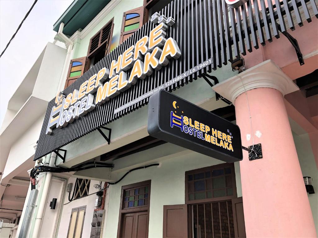 a sign on the side of a building at Sleep Here Hostel, Melaka in Melaka