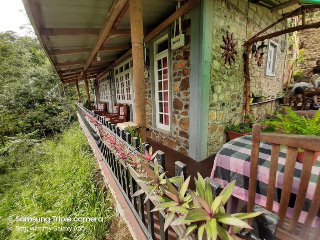 une terrasse couverte d'une maison avec une table et des chaises dans l'établissement Biwon Homestay, à Ella