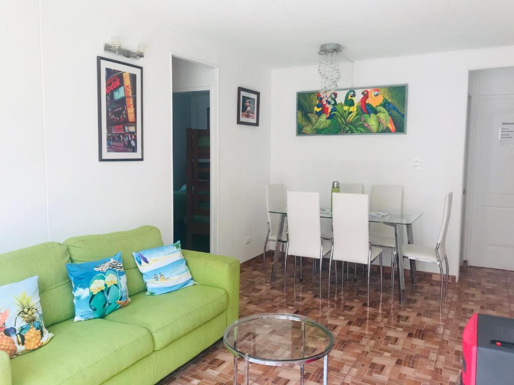 sala de estar con sofá verde y mesa en Cosmopolita Verde, en La Serena